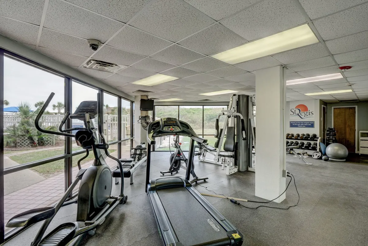 A bright, modern fitness center featuring treadmills, ellipticals, weightlifting equipment, and large windows letting in plenty of natural light. The space feels motivational and inviting, perfect for workouts and personal training sessions.